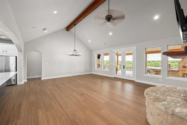 727 S Sugartree Dr, Lipan, TX 76462 - unfurnished living room with beamed ceiling, a wealth of natural light, wood finished floors, and ceiling fan with notable chandelier