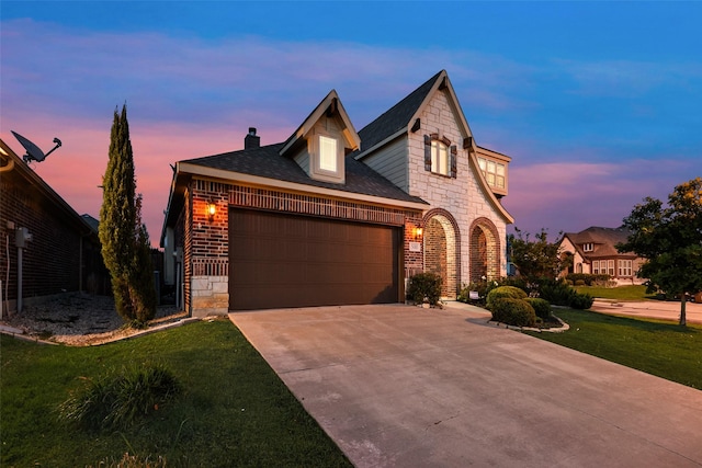 view of front of property with a front lawn, a garage, driveway, stone siding, and a chimney
