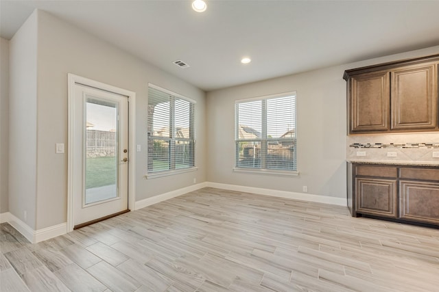 unfurnished dining area featuring visible vents, recessed lighting, light wood finished floors, and baseboards