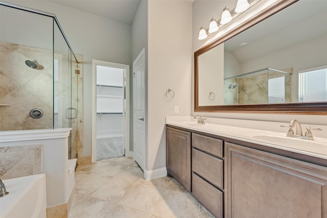 bathroom with double vanity, a bath, a sink, a spacious closet, and a stall shower