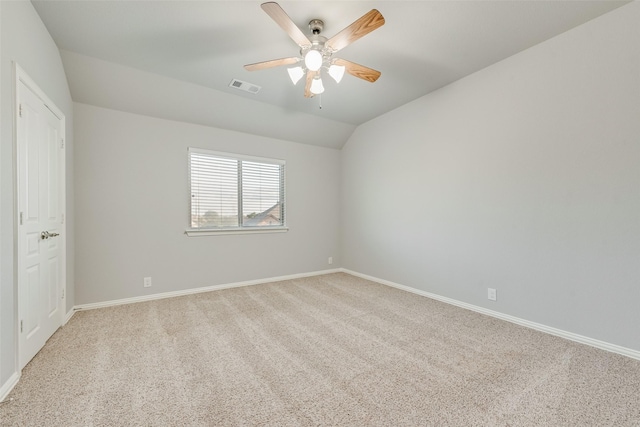 interior space featuring a ceiling fan, visible vents, light carpet, baseboards, and lofted ceiling