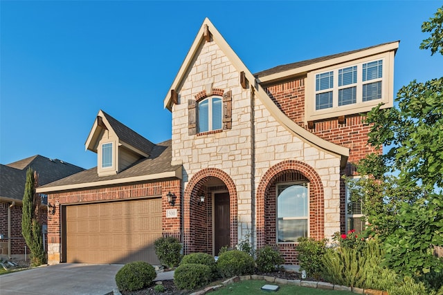 view of front of home featuring a garage, concrete driveway, brick siding, and stone siding
