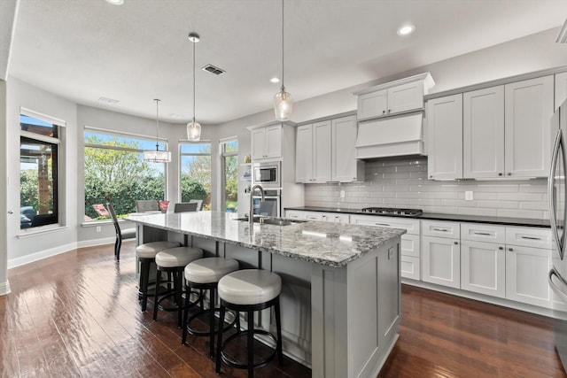 kitchen featuring decorative backsplash, appliances with stainless steel finishes, baseboards, recessed lighting, and dark wood finished floors