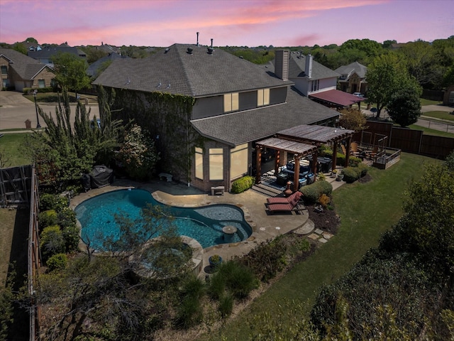 view of swimming pool with a pool with connected hot tub, a yard, a patio, and a fenced backyard