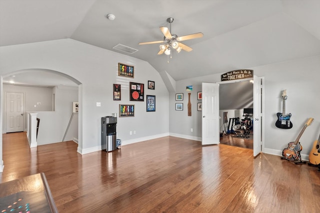 unfurnished living room featuring lofted ceiling, visible vents, arched walkways, wood finished floors, and a ceiling fan