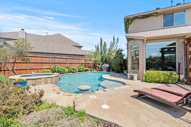 view of swimming pool featuring a pool with connected hot tub, a fenced backyard, and a patio area