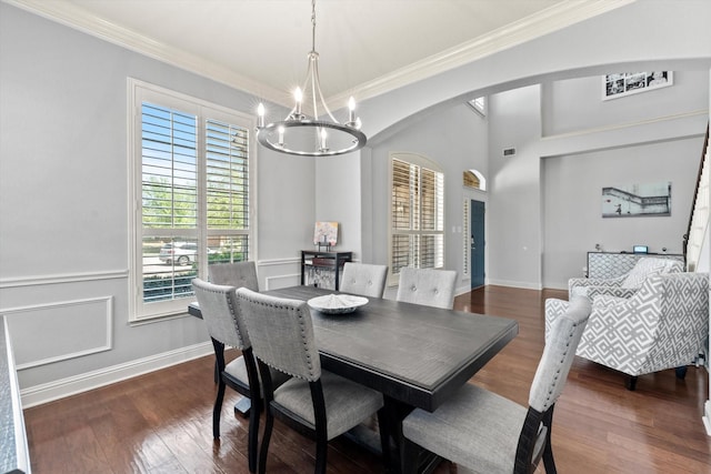 dining area with a chandelier, arched walkways, crown molding, and dark wood-type flooring