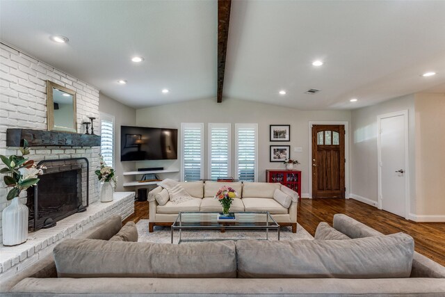living room with a fireplace, wood finished floors, visible vents, and vaulted ceiling with beams