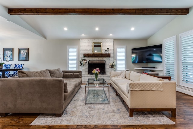 living area featuring vaulted ceiling with beams, dark wood-type flooring, and plenty of natural light