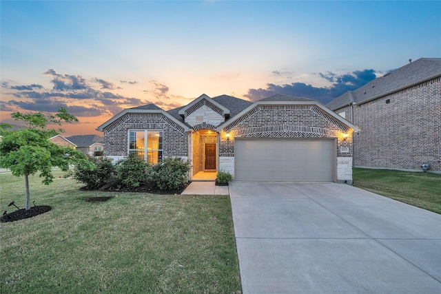 view of front of property featuring driveway, a lawn, brick siding, and a garage