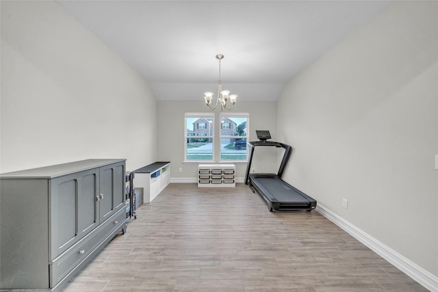 workout area with light wood-style floors, a notable chandelier, vaulted ceiling, and baseboards