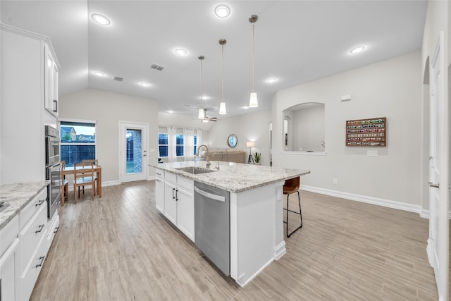 kitchen featuring a sink, a breakfast bar area, a ceiling fan, visible vents, and dishwasher