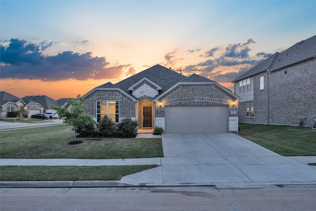 view of front of home with driveway, a yard, an attached garage, and brick siding