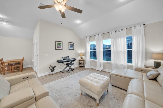 living area featuring visible vents, baseboards, vaulted ceiling, wood finished floors, and a ceiling fan