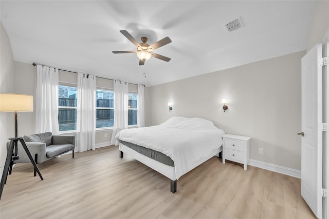 bedroom featuring visible vents, ceiling fan, light wood-style floors, and baseboards