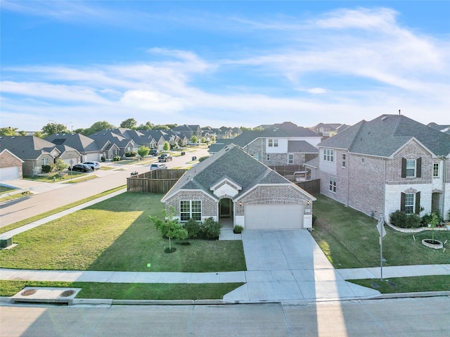 view of front of house featuring a residential view, a front yard, driveway, and brick siding