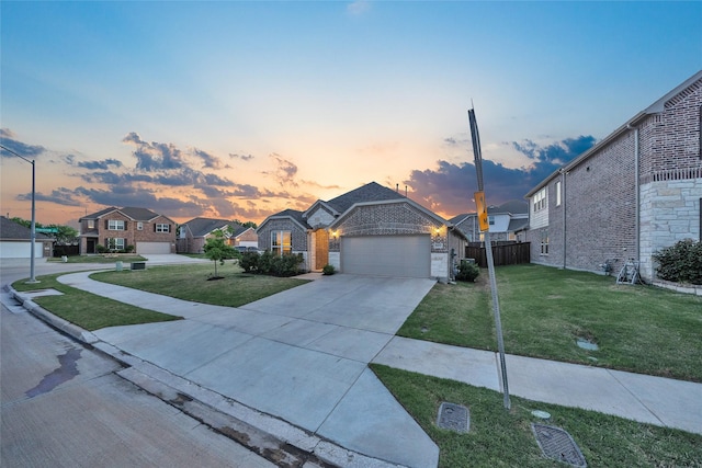 ranch-style home featuring a lawn, fence, brick siding, and a garage