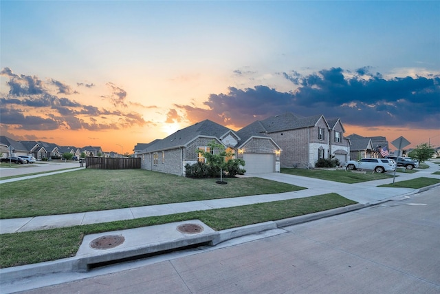 view of front of home with driveway, a residential view, stone siding, fence, and a front lawn