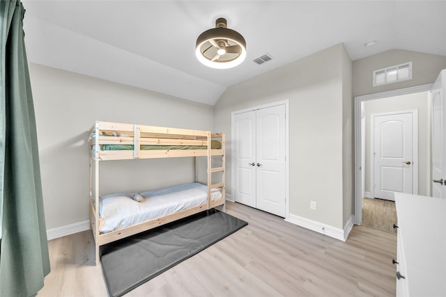 bedroom featuring wood finished floors, visible vents, and vaulted ceiling