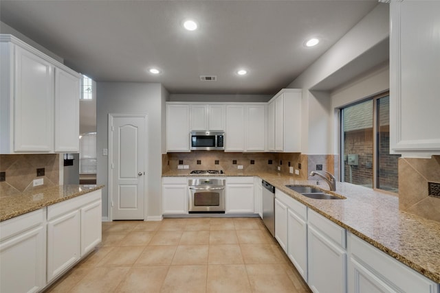 kitchen featuring a sink, white cabinets, backsplash, and stainless steel appliances