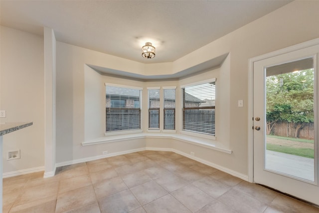 unfurnished dining area featuring light tile patterned floors and baseboards