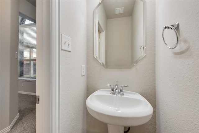 bathroom with baseboards and a sink