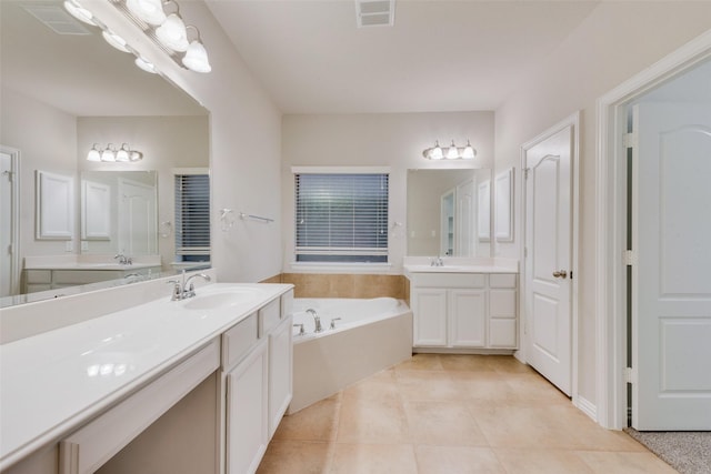 full bath featuring a sink, visible vents, two vanities, a bath, and tile patterned floors