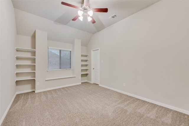 unfurnished bedroom with lofted ceiling, visible vents, ceiling fan, baseboards, and light carpet