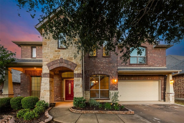 traditional-style home featuring a garage, brick siding, and concrete driveway