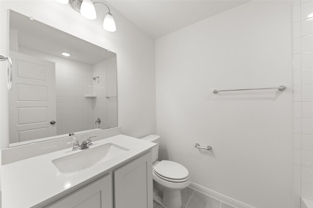 full bath with tiled shower / bath combo, tile patterned flooring, toilet, vanity, and baseboards