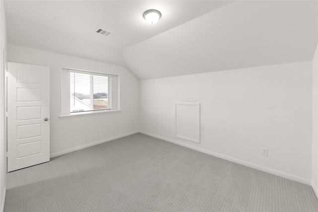 additional living space featuring visible vents, vaulted ceiling, carpet, and baseboards