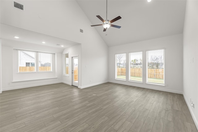 unfurnished living room with visible vents, a wealth of natural light, and wood finished floors
