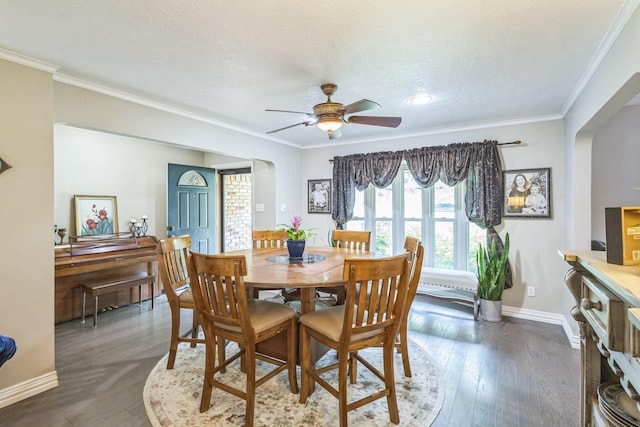 dining room with ceiling fan, dark wood-style flooring, arched walkways, baseboards, and ornamental molding