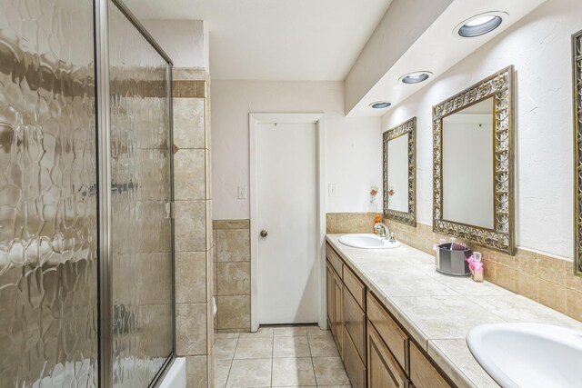 bathroom with a tile shower, vanity, toilet, tile walls, and tasteful backsplash