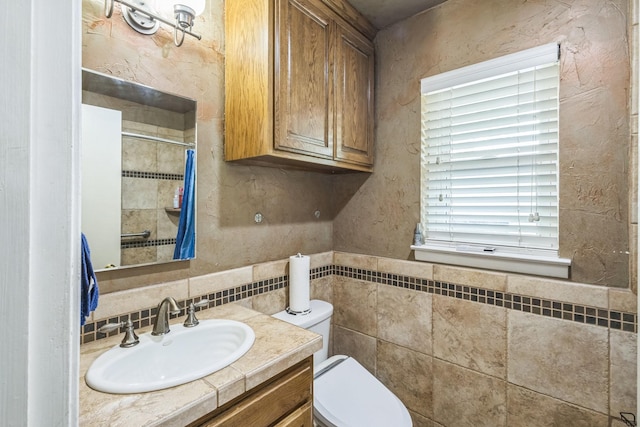 full bath with vanity, toilet, tile walls, decorative backsplash, and tiled shower