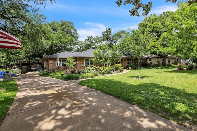 ranch-style house featuring driveway, a front lawn, and brick siding