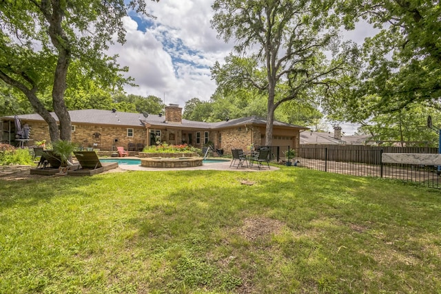 rear view of property featuring a yard, brick siding, fence, and a chimney
