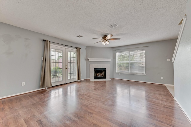 unfurnished living room featuring visible vents, a ceiling fan, a textured ceiling, and wood finished floors