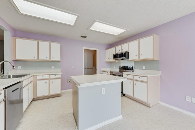 kitchen featuring a sink, light countertops, stainless steel appliances, light floors, and visible vents