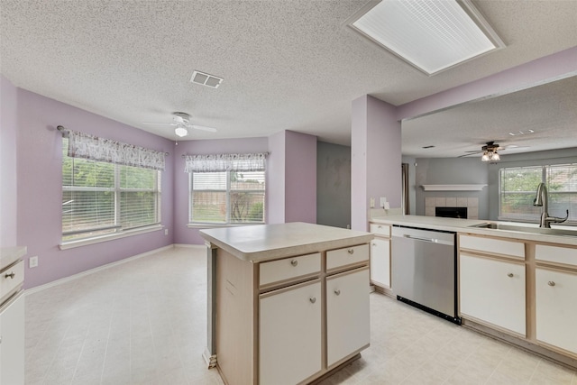 kitchen featuring a sink, stainless steel dishwasher, a ceiling fan, and visible vents