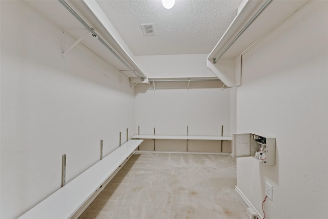 walk in closet featuring visible vents and carpet