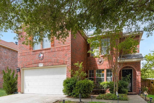 traditional-style home with concrete driveway, brick siding, and an attached garage