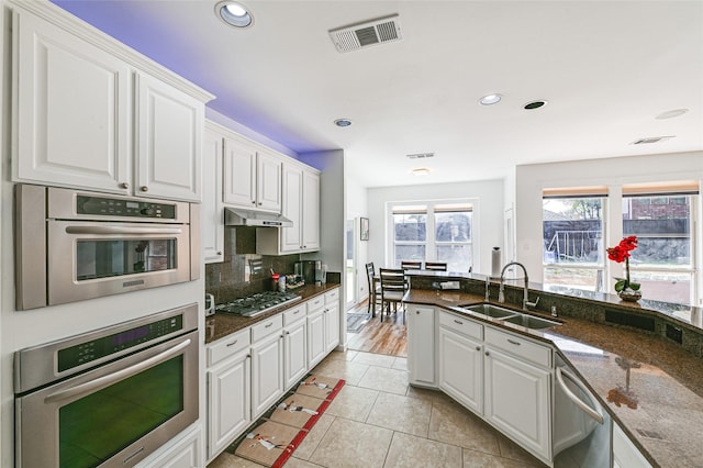 12165 Shoal Creek Dr, Frisco, TX 75035 - kitchen with appliances with stainless steel finishes, a sink, white cabinets, backsplash, and recessed lighting