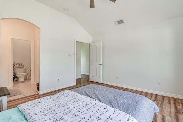 12165 Shoal Creek Dr, Frisco, TX 75035 - bedroom featuring arched walkways, vaulted ceiling, wood finished floors, and baseboards