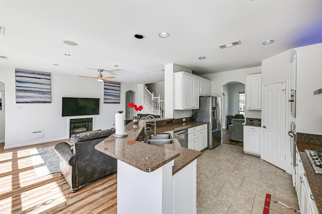 12165 Shoal Creek Dr, Frisco, TX 75035 - kitchen featuring arched walkways, a sink, appliances with stainless steel finishes, open floor plan, and a ceiling fan