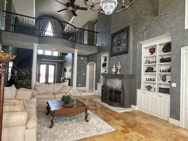 1900 Durance Ct, Corinth, TX 76210 - living room with a high ceiling, arched walkways, ornate columns, and ceiling fan with notable chandelier