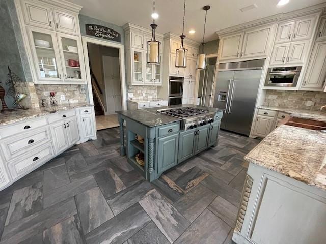1900 Durance Ct, Corinth, TX 76210 - kitchen with tasteful backsplash, stainless steel appliances, light stone countertops, and a kitchen island