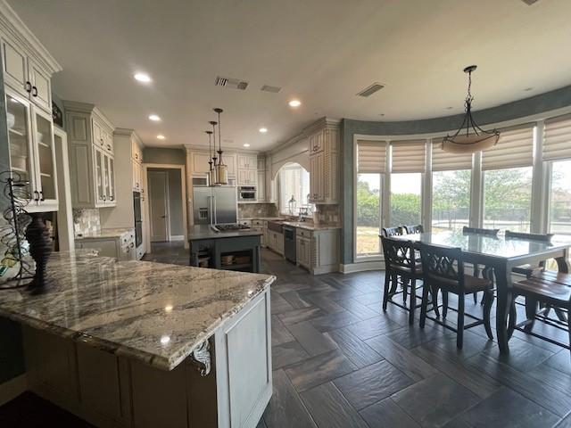 1900 Durance Ct, Corinth, TX 76210 - kitchen featuring recessed lighting, light stone counters, built in fridge, dishwasher, and visible vents