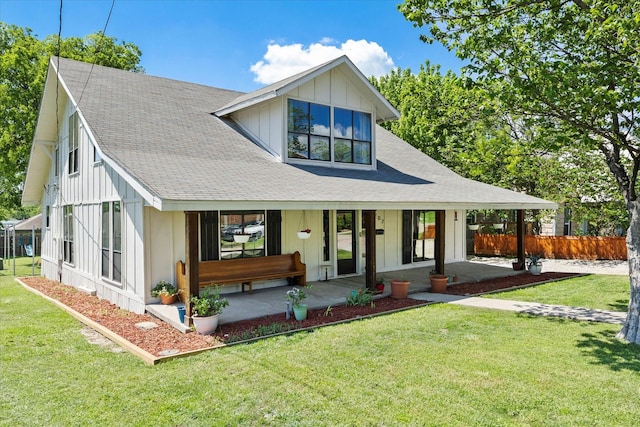 view of front of home featuring a porch, a front yard, board and batten siding, roof with shingles, and fence
