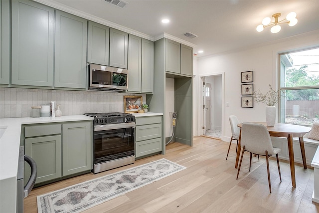 5105 Birchman Ave, Fort Worth, TX 76107 - kitchen featuring range with gas stovetop, stainless steel microwave, visible vents, green cabinets, and backsplash